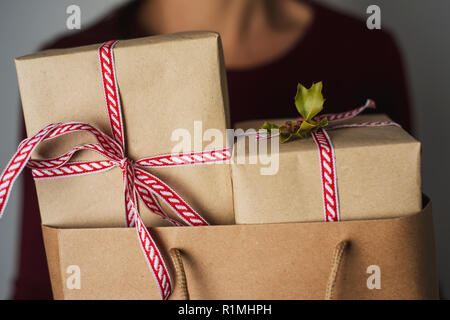 Libre d'un young caucasian woman holding a paper panier plein de cadeaux contre un fond blanc Banque D'Images