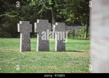 Vieilles pierres tombales identiques placés dans la rangée sur l'herbe au cimetière Banque D'Images