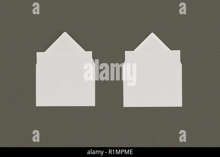 Vue de dessus de l'ouverture des enveloppes blanches avec des cartes vierges isolé sur gray Banque D'Images