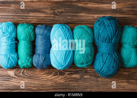 Vue du haut de vert et bleu fil à tricoter clews sur surface en bois Banque D'Images