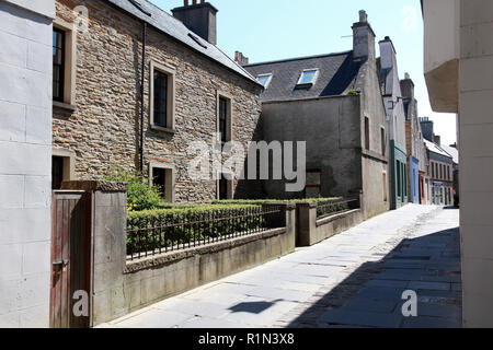 Une vieille maison en grès Stromness, Orkney avec pierres de pavage d'une carrière locale et de galets pierres dans le centre de la rue. Banque D'Images