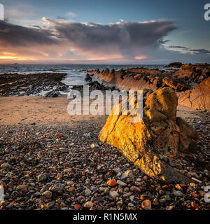 Tôt le matin la lumière frappant un gros rocher sur la plage à St Monans sur la côte est de l'Ecosse Banque D'Images