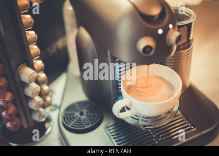 Les capsules de café expresso et bouilloire machine sur une table en bois, le flou des dosettes de café et les fèves background Banque D'Images