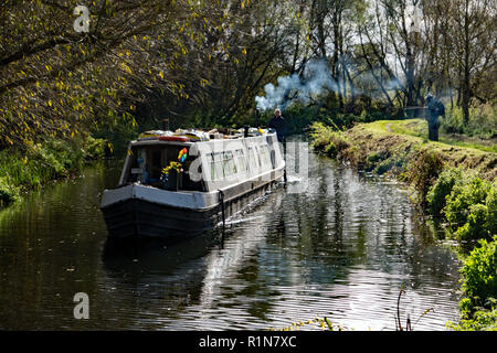 Un canal étroit, ou bateau, passant deux pêcheurs pêcher sur les rives de la rivière stort peut en Sawbridgeworth, Hertfordshire. Banque D'Images