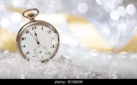 Compte à rebours du Nouvel An. Minutes à minuit sur une vieille montre, bokeh background festive Banque D'Images