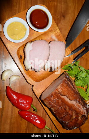 Kassler sur plaque rustique en bois. Il est souvent servi avec de la choucroute et de la purée de pommes de terre. Guéri complètement cuite et des côtelettes de porc fumé sur un plateau en bois Banque D'Images