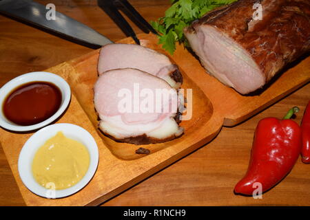 Kassler sur plaque rustique en bois. Il est souvent servi avec de la choucroute et de la purée de pommes de terre. Guéri complètement cuite et des côtelettes de porc fumé sur un plateau en bois Banque D'Images