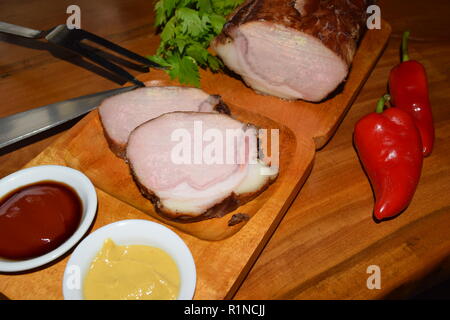 Kassler sur plaque rustique en bois. Il est souvent servi avec de la choucroute et de la purée de pommes de terre. Guéri complètement cuite et des côtelettes de porc fumé sur un plateau en bois Banque D'Images