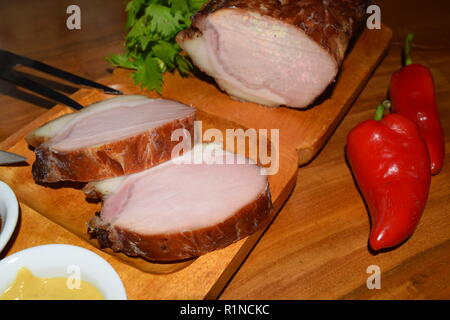 Kassler sur plaque rustique en bois. Il est souvent servi avec de la choucroute et de la purée de pommes de terre. Guéri complètement cuite et des côtelettes de porc fumé sur un plateau en bois Banque D'Images