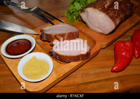 Kassler sur plaque rustique en bois. Il est souvent servi avec de la choucroute et de la purée de pommes de terre. Guéri complètement cuite et des côtelettes de porc fumé sur un plateau en bois Banque D'Images