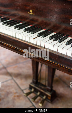 Un grand piano et clavier vintage pédales, montrant des années d'usure, avec une touche bloquée. Banque D'Images