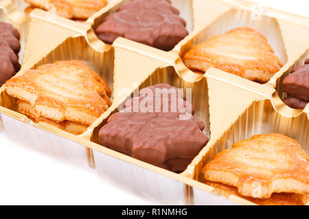 Les cookies dans la boîte en plastique sur fond blanc. Banque D'Images