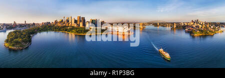 Ferry à Sydney passager Manli au milieu du port de Sydney au large de Circular Quay à large panorama aérien dans de doux soleil du matin la lumière. Banque D'Images