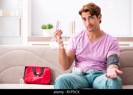 Homme malade à la maison avec une trousse de premiers secours Banque D'Images