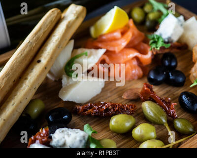 Assiette de fromage avec du saumon, citron, pain et stcks olivas Banque D'Images