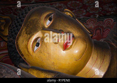 Golden Buddha couché géant dans les grottes peintes Dambula rock, Sri Lanka. Close up détails de la tête. Banque D'Images