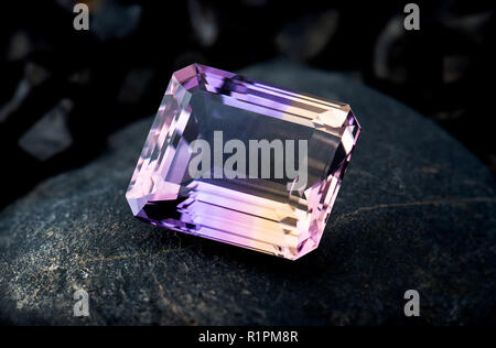 Ametrin gemstone bijoux avec pierre noire et l'éclairage de fond sombre. Banque D'Images