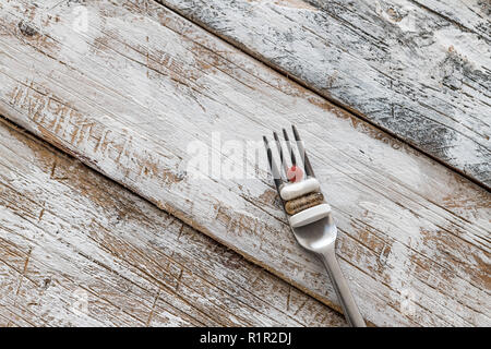 Comprimés avec fourche argent sur une vieille table en bois avec peinture blanche Banque D'Images