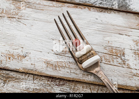 Comprimés avec fourche argent sur une vieille table en bois avec peinture blanche Banque D'Images