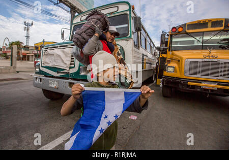 Tijuana, au Mexique. 13Th Nov, 2018. Peu de Mario Barra est titulaire d'un drapeau du Honduras comme lui et son père viennent d'un petit-déjeuner 'lieu de rencontre'. Un nouveau groupe de migrants d'Amérique centrale a atteint la ville frontière de Tijuana sur leur chemin vers les États-Unis. La semaine dernière, le président américain, Trump resserré les règlements pour les procédures d'asile à la frontière sud des États-Unis. Le Parti républicain a ordonné que les migrants qui traversent illégalement la frontière vers les États-Unis d'être refusé l'asile. Credit : Omar Martinez/dpa/Alamy Live News Banque D'Images