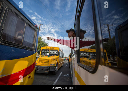 Tijuana, au Mexique. 13Th Nov, 2018. Un migrant souligne un autre autobus à partir de la fenêtre d'un bus comme il conduit à un 'point' petit déjeuner-réunion avec un groupe - distribué dans plusieurs autobus et camions. Un nouveau groupe de migrants d'Amérique centrale a atteint la ville frontière de Tijuana sur leur chemin vers les États-Unis. La semaine dernière, le président américain, Trump resserré les règlements pour les procédures d'asile à la frontière sud des États-Unis. Le Parti républicain a ordonné que les migrants qui traversent illégalement la frontière vers les États-Unis d'être refusé l'asile. Credit : Omar Martínez/dpa/Alamy Live News Banque D'Images