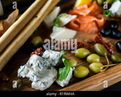 Assiette de fromage avec du saumon, citron, pain et stcks olivas Banque D'Images
