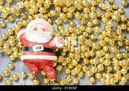 Jouet de Noël Père Noël sur perles d'or. Close-up. Banque D'Images