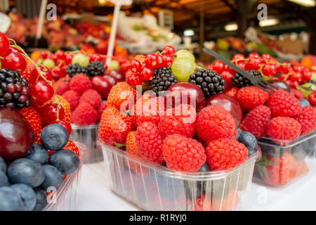 Corbeilles de fruits frais, de petits fruits, fraises, framboises, raisins, mûres à la vente à un décrochage du marché. Close up food Banque D'Images