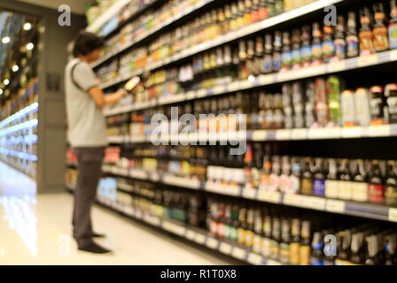 Résumé Un homme de regarder les marchandises en avant du plateau d'épicerie dans un magasin de détail Banque D'Images