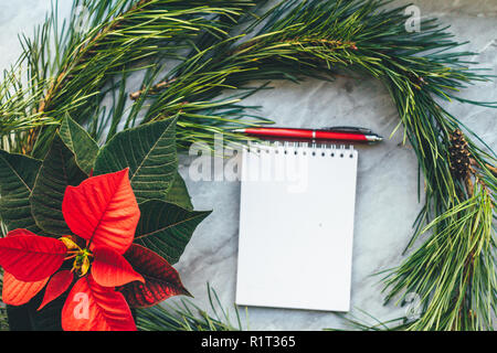 Gros plan de Noël poinsettia avec maquette, couronne de pin, l'ordinateur portable, avec l'exemplaire. Fond confortable Banque D'Images