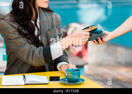 Portrait de femme de payer par carte de crédit sur la borne de paiement in cafe Banque D'Images