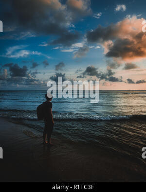 Silhouette d'un homme debout à la plage profiter de la vue magnifique de la nature pendant le coucher du soleil Banque D'Images