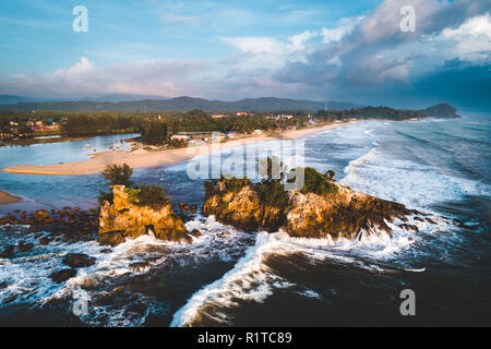 Image aérienne de vagues se brisant sur les piles de la mer à la plage au lever du soleil, en période de mousson en Malaisie Banque D'Images