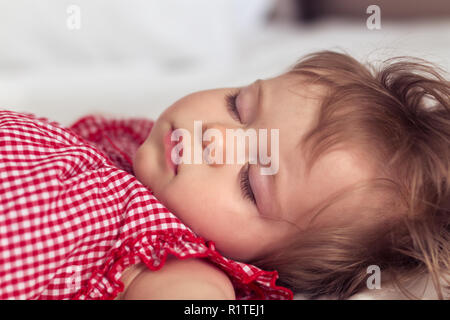 Portrait d'une belle petite fille de 9 mois, dormir sur fond flou. Image visage d'enfants dormir. Cute infant kid. Portrait de l'enfant au cours des Banque D'Images