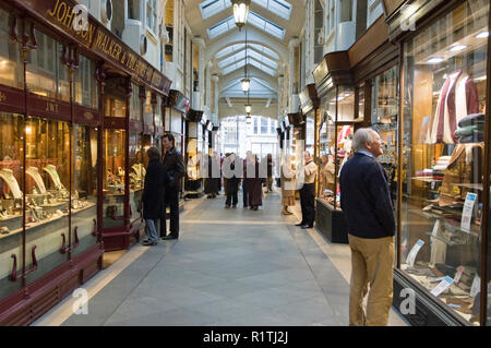 Clients dans la Burlington Arcade, une galerie marchande couverte qui court derrière Bond Street de Piccadilly à Burlington Gardens, Londres. Banque D'Images