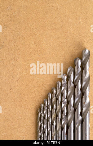 Bien utilisés et la rouille specked twist drill bits sur un vieux MDF board with copy space Banque D'Images