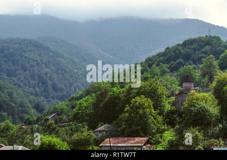 Dilijan, l'Arménie, le 24 août 2018:un épais brouillard s'étend sur les montagnes avec la forêt et la chapelle de Saint Sarkis dans le village de Gosh, situé près de l'œillet Banque D'Images