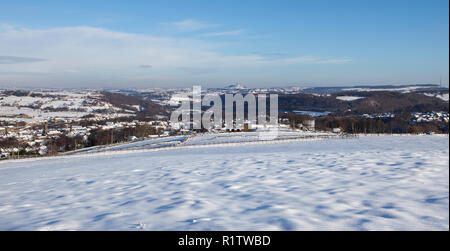 Vue panoramique sur la vallée de la Basse-Holme en hiver avec de la neige sur le sol, et la ville de Meltham visible au fond de la vallée Banque D'Images