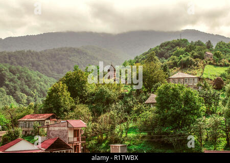 Dilijan, l'Arménie, le 24 août 2018:chapelle de Saint Sarkis et de maisons dans le village de montagne de gosh avec un ciel sombre de brouillard épais, situé dans le d Banque D'Images