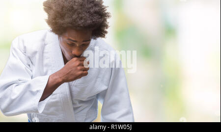 South American man wearing kimono karaté sur fond isolé de malaise et la toux comme symptôme de rhume ou de bronchite. Concept de soins de santé. Banque D'Images