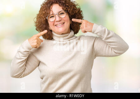 Beau milieu ager senior woman wearing pullover à col roulé et verres sur fond isolé sourire confiant montrant et en pointant avec les doigts Banque D'Images