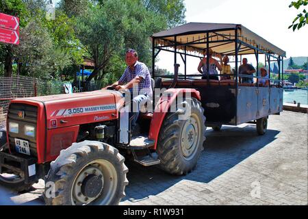 Dalyan, Turquie - 9 juillet 2018 : les touristes embarquent le tracteur de navette jusqu'à la ville de Dalyan ruines antiques de Kaunos site du patrimoine mondial. Banque D'Images