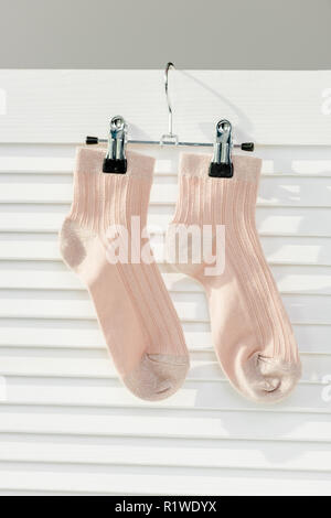 Close up de chaussettes rose accroché sur White room divider Banque D'Images