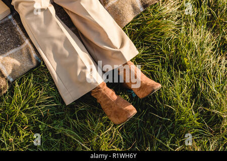 La section basse des jambes en daim chaussures brunes sur l'herbe en plein air Banque D'Images