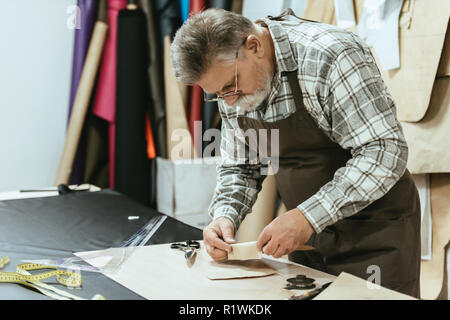 Sac à main homme artisan en tablier et au studio de travail lunettes Banque D'Images