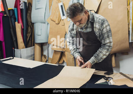 Sac à main homme tablier artisan en travaillant avec du carton au studio Banque D'Images