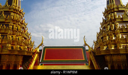 Temple coloré pavillon entre les deux tours d'or à Bangkok avec des nuages en arrière-plan Banque D'Images