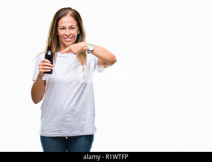 L'âge moyen hispanic woman drinking beer sur fond isolé très heureux pointant avec la main et des doigts Banque D'Images