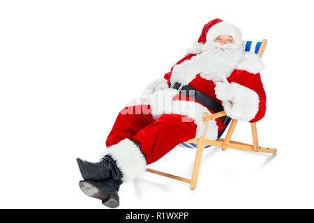 Santa Claus showing thumb up et de détente sur chaise de plage on white Banque D'Images