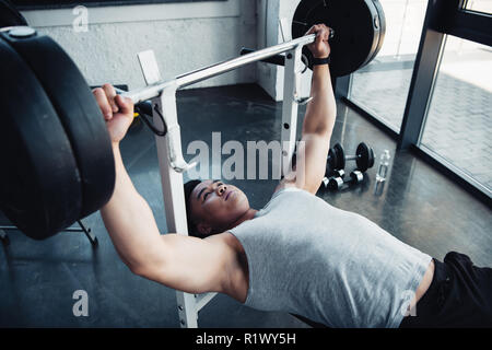 L'exercice sportif musculaire avec barbell at gym Banque D'Images